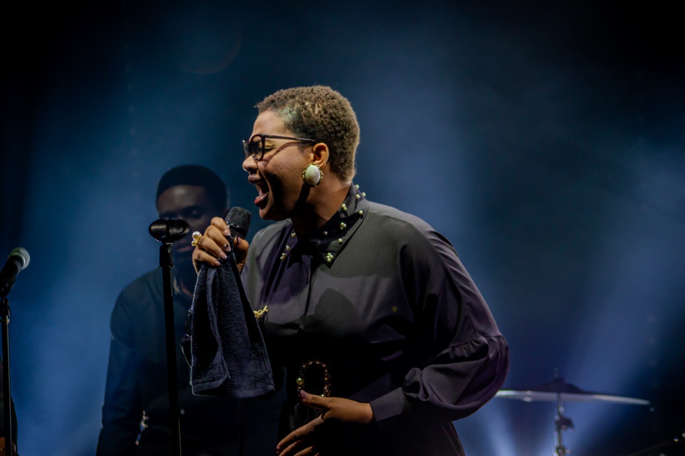 Close-up of a singer performing on stage during a music video shoot by TECHINRI AGENCY
