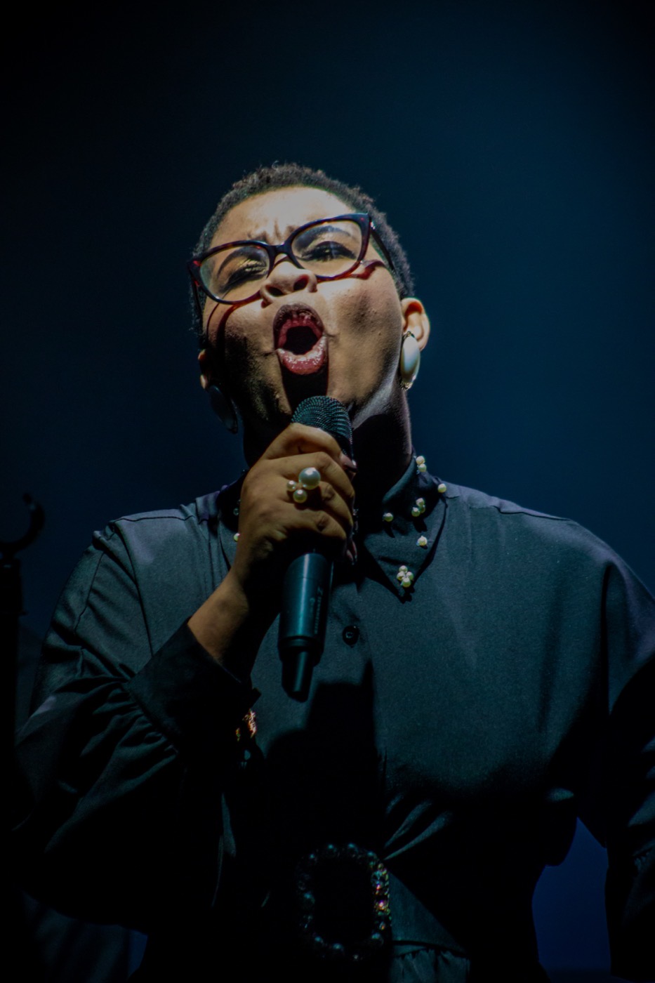 Vocalist singing under stage lighting during a music video production by TECHINRI AGENCY